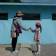 A woman and a girl shake hands over a replica of the barrier seperating North and South Korea